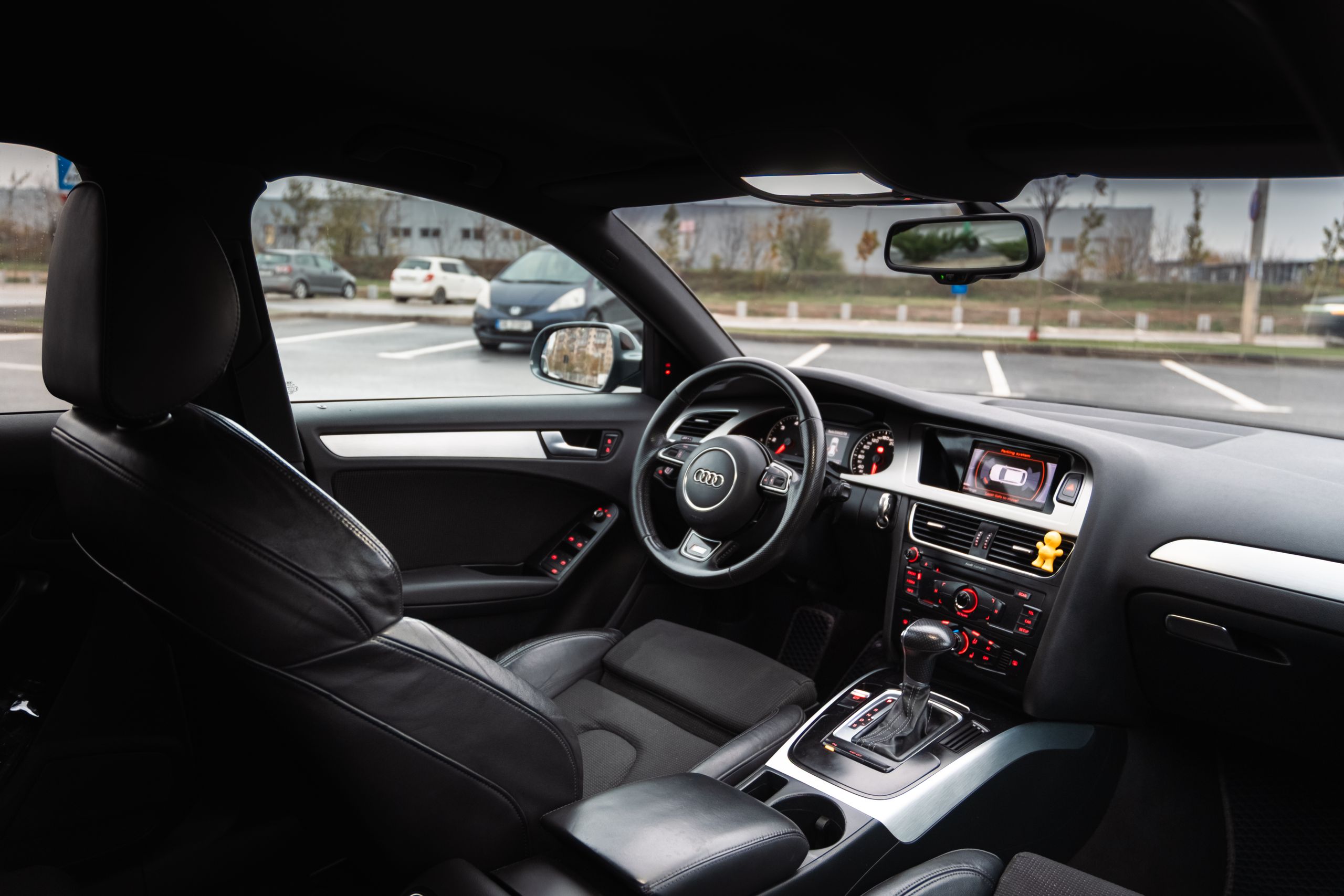 Interior of a luxury car featuring black leather seats, sleek dashboard, and modern controls.